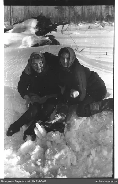 Two women sitting on snow