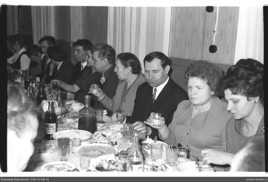 Мужчины и женщины за столом с едой и напитками