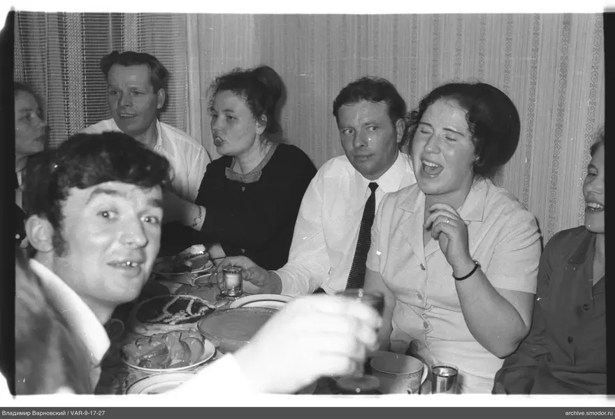 Group sitting at a table with dishes and snacks