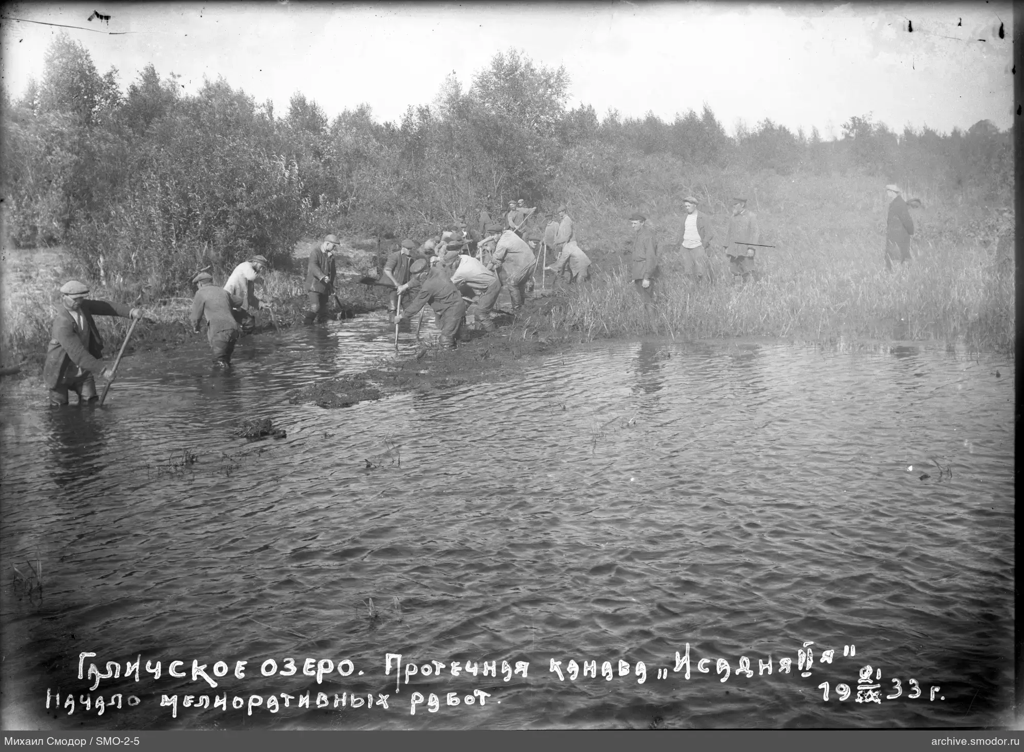 Мужчины работают в воде и на берегу