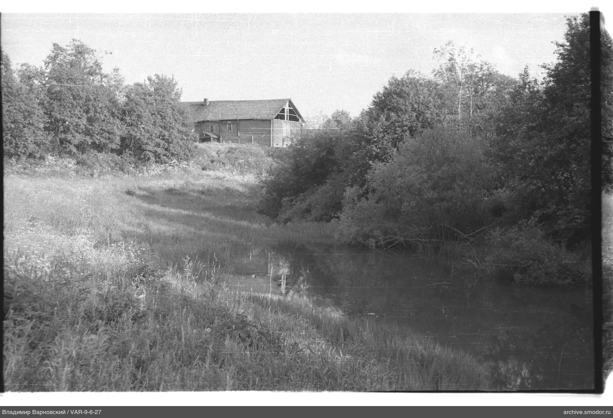 Landschaft mit Fluss und Holzgebäude