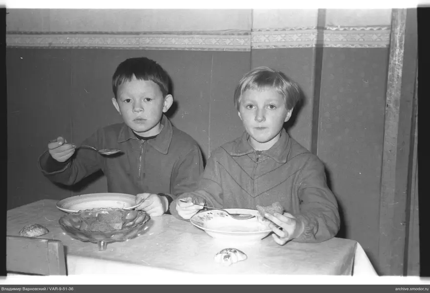 Zwei Jungen am Tisch mit Suppe und Brot