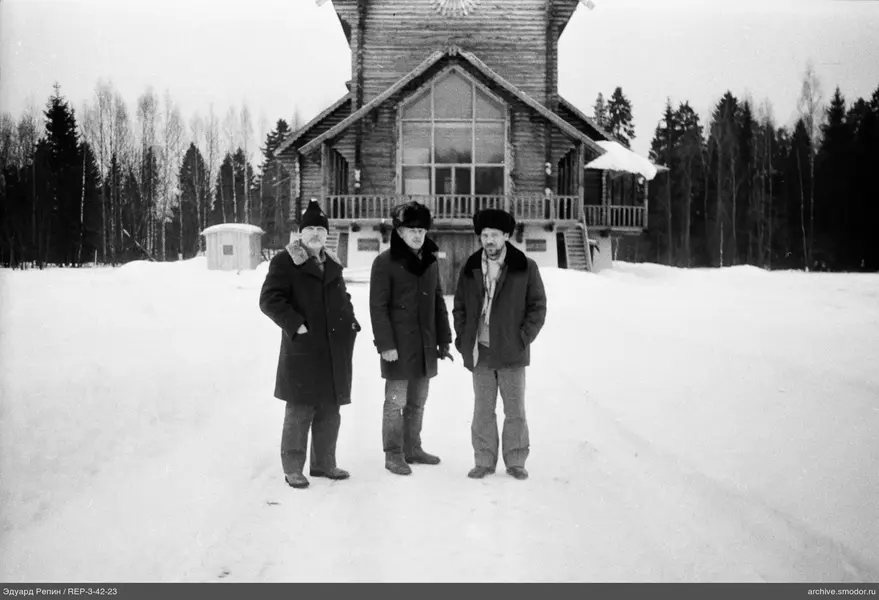 Gruppe von Männern vor einem Holzhaus