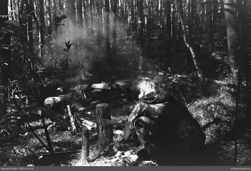 Mann am Lagerfeuer im Wald