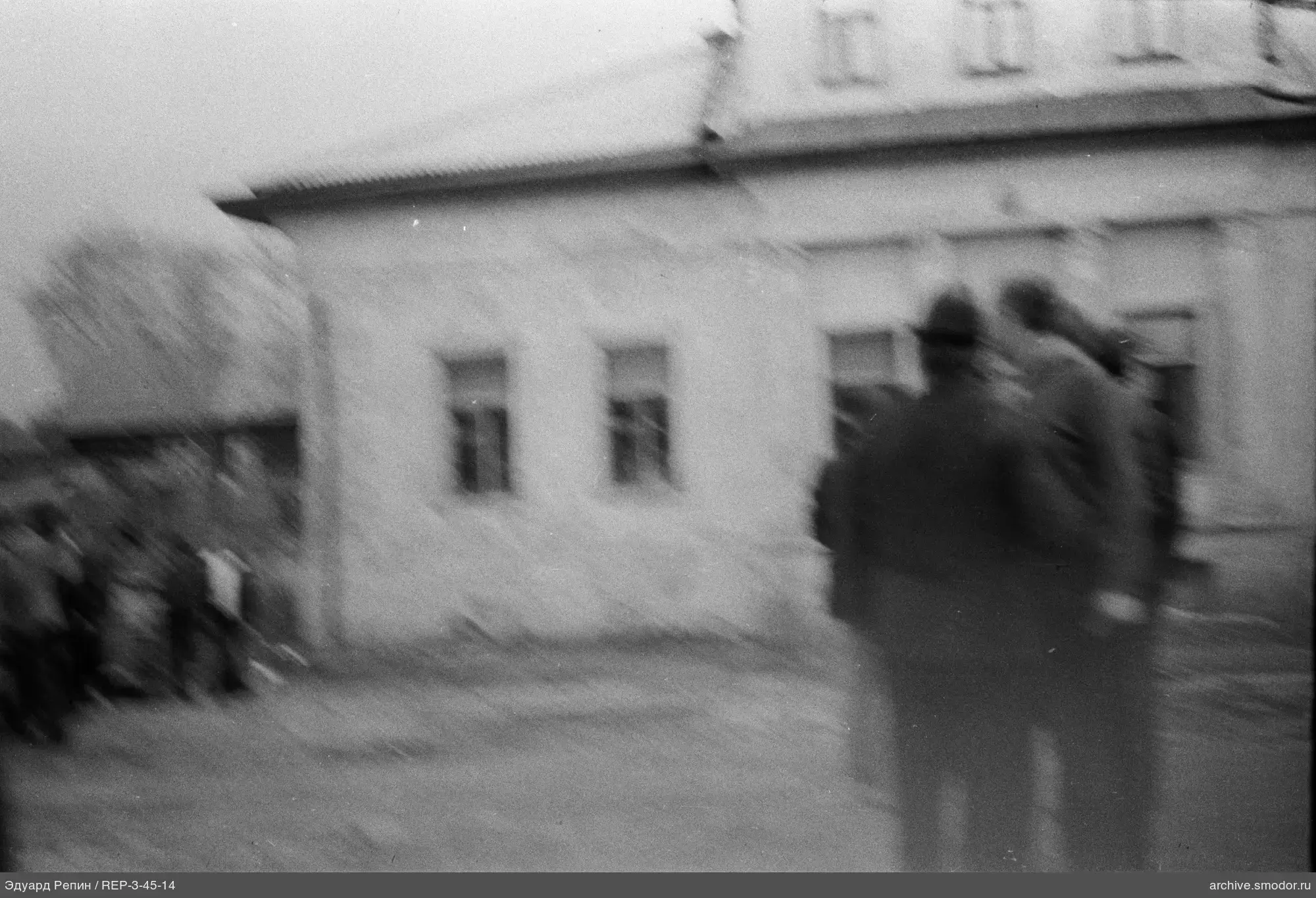 Men with backs and buildings in background