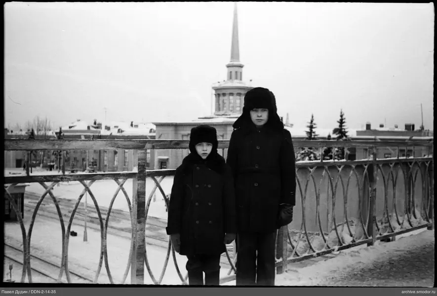 Два мальчика на мосту в зимней одежде