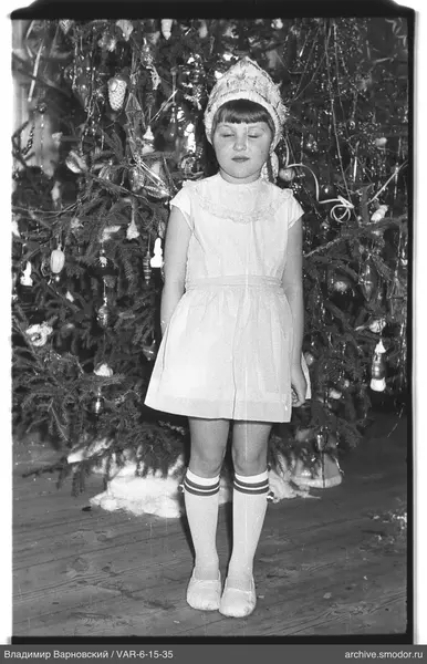 Mädchen vor geschmücktem Weihnachtsbaum