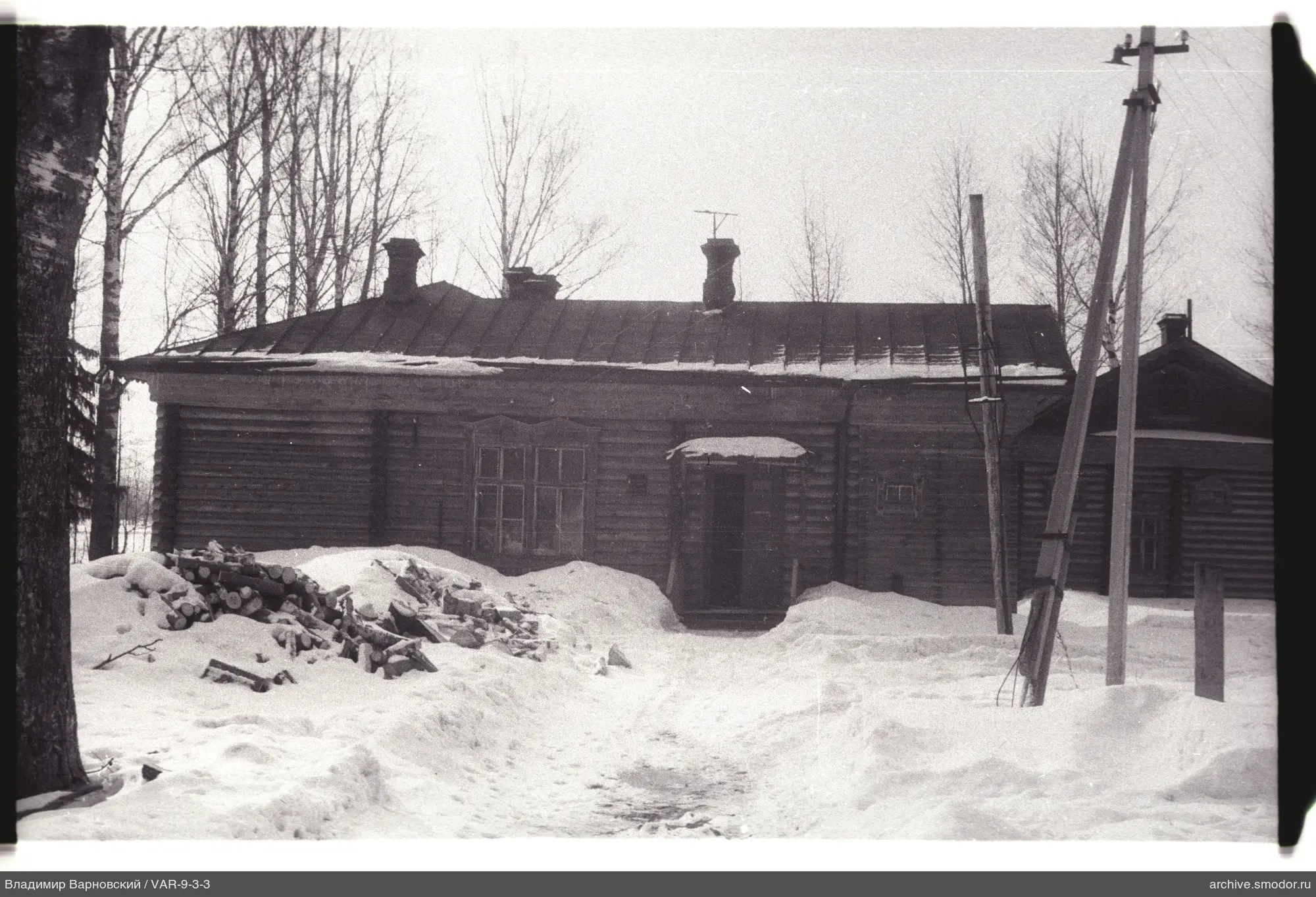 Holzhaus mit Holzstapeln und Drähten