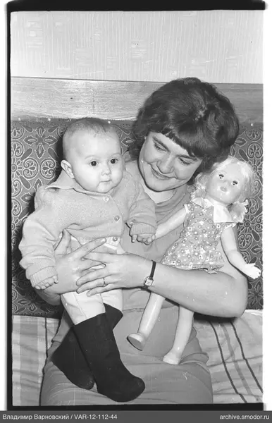 Woman with child and doll on sofa