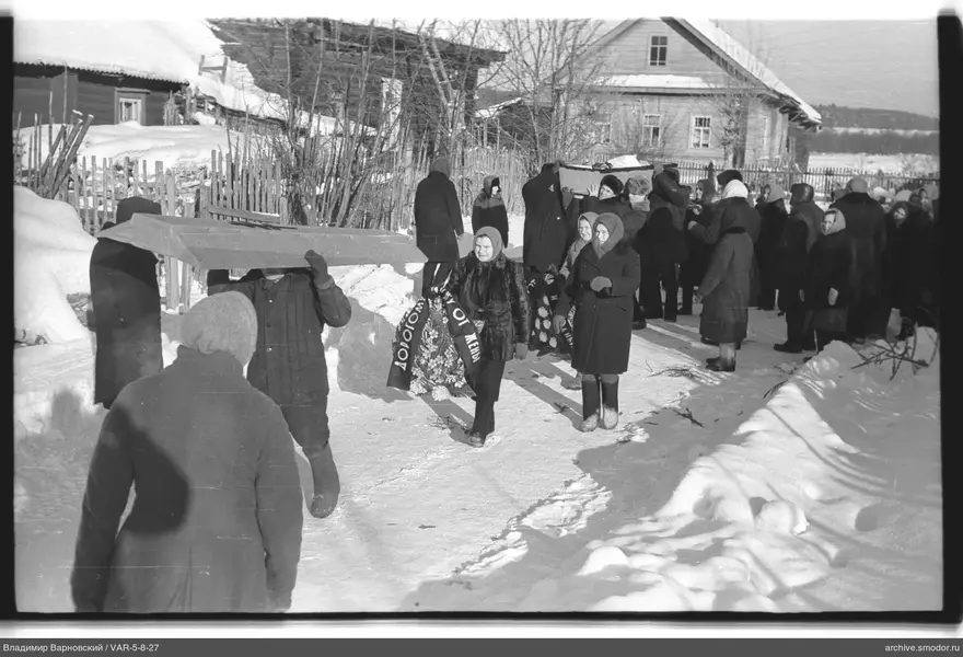 Группа людей с гробами на заснеженной дороге