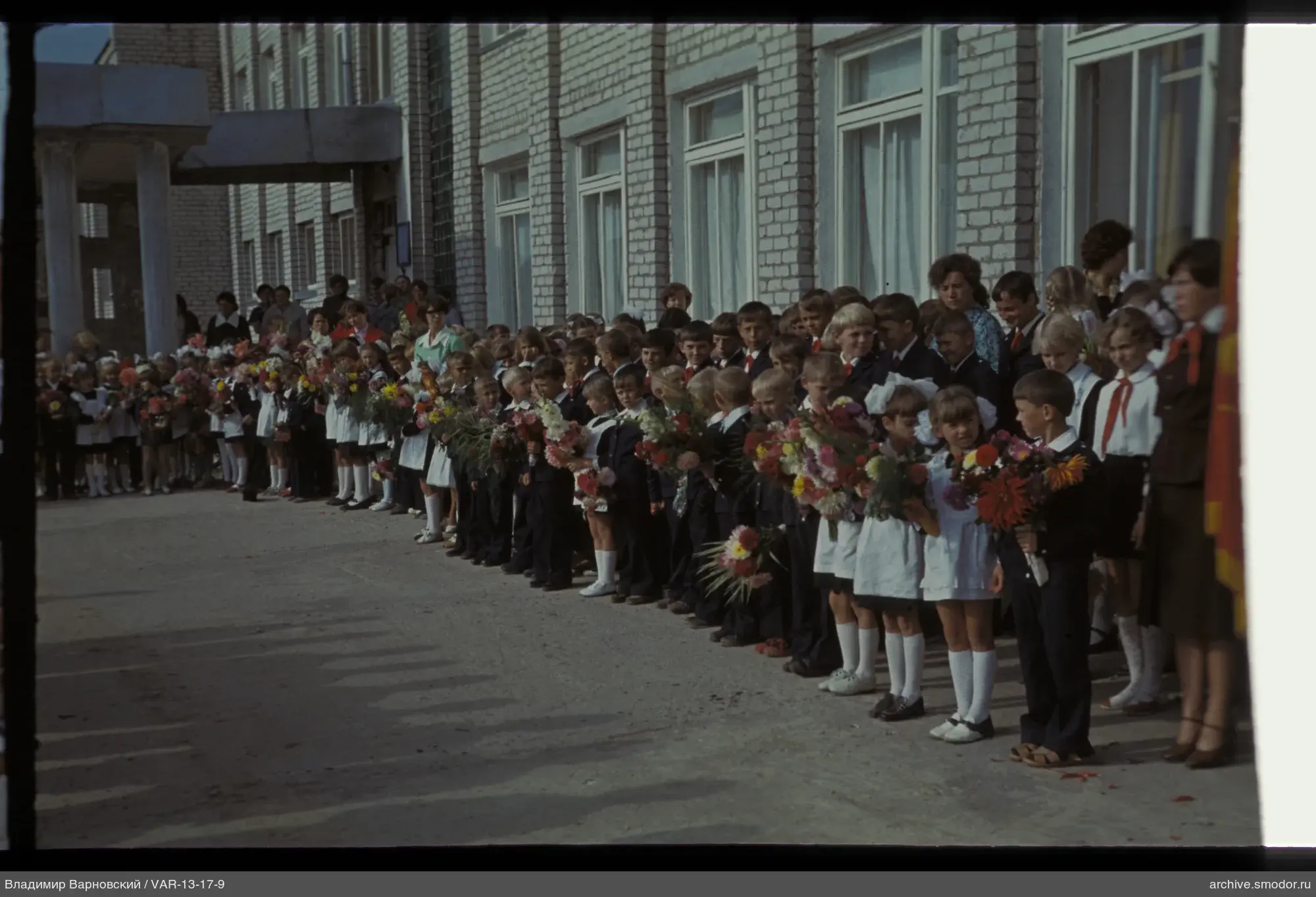 Gruppe von Kindern und Erwachsenen am Backsteingebäude