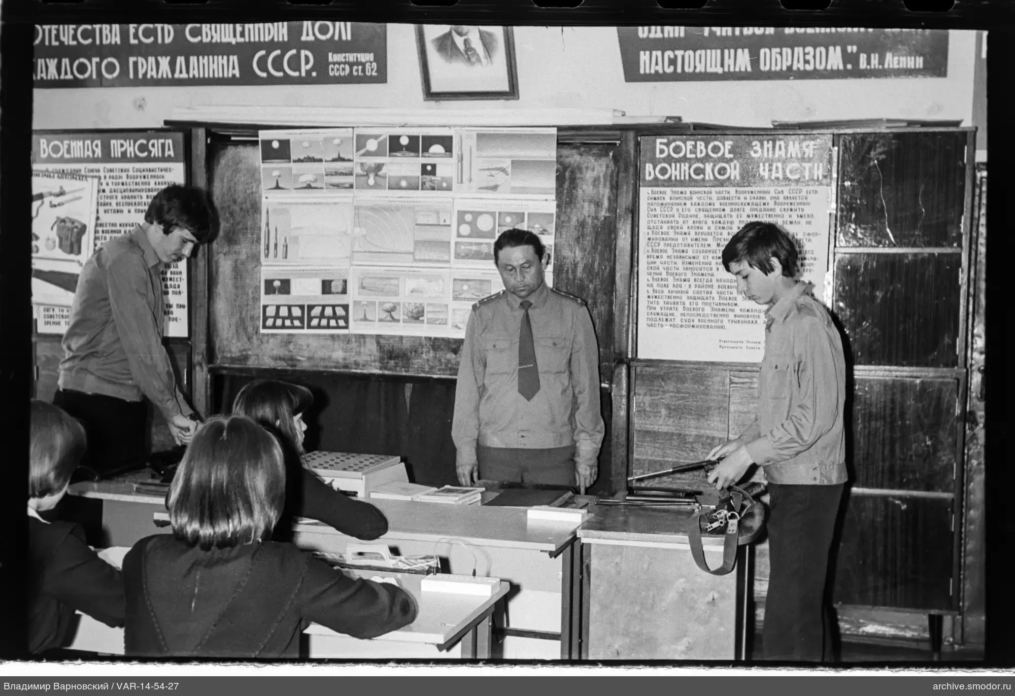 Мужчины и женщины в классе с плакатами и оружием