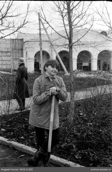 Девушка с лопатой и женщина на фоне здания