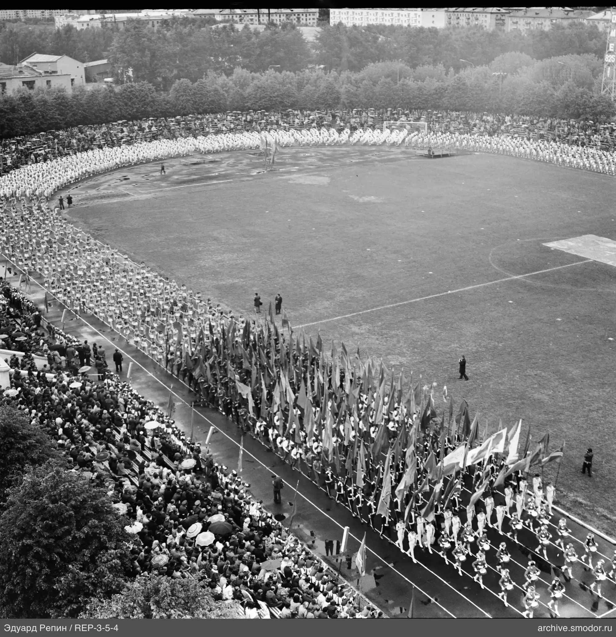 Menschen in Kolonnen am Stadion mit Fahnen