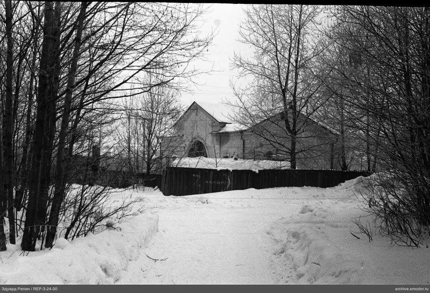 Schneebedeckte Straße und Haus mit Zaun