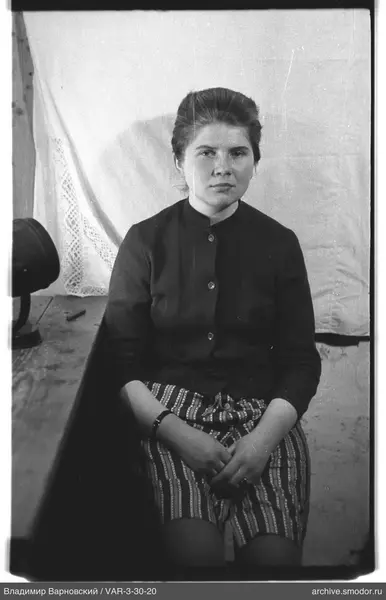 Portrait of a seated woman in cardigan and skirt