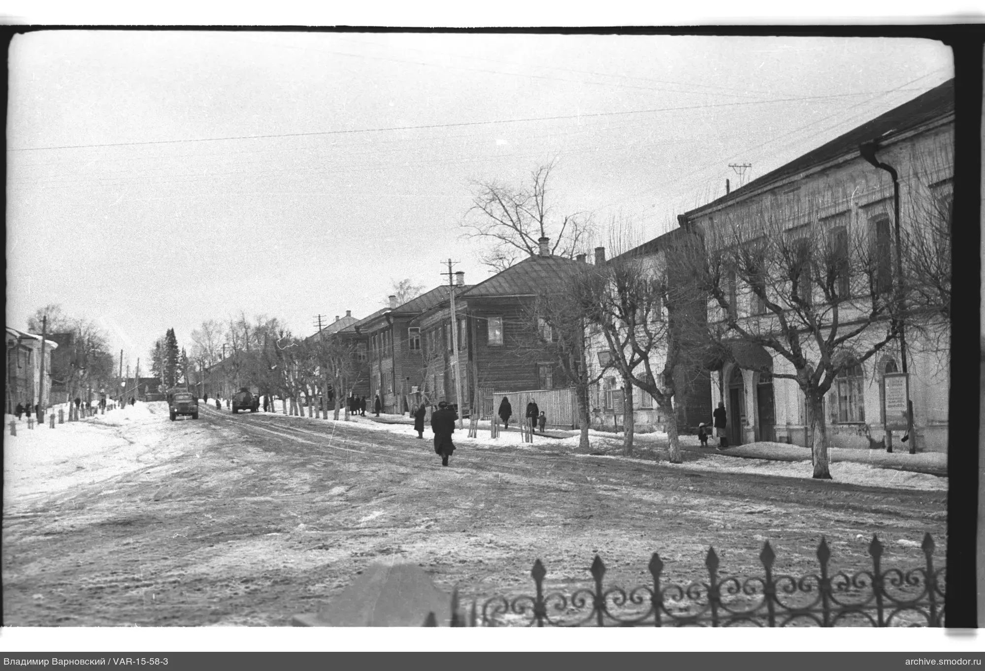 Verschneite Straße mit Gebäuden und Bäumen