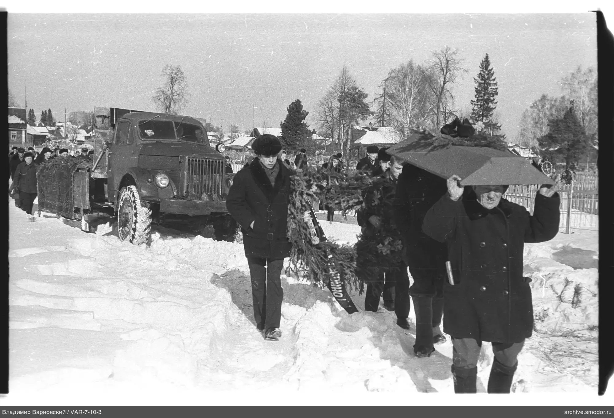 Gruppe mit Sarg auf verschneiter Straße