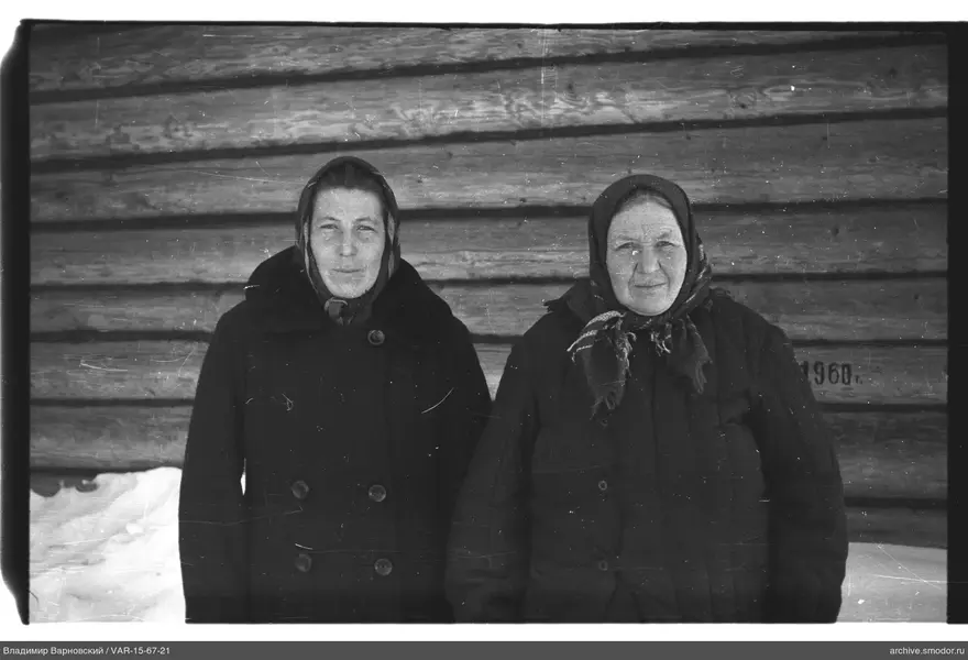 Две женщины у деревянной стены с надписью 1960