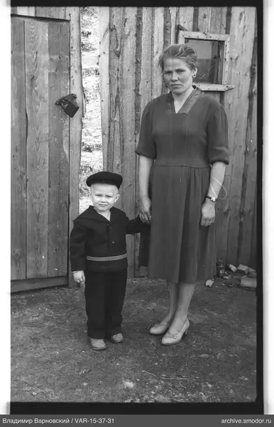 Frau und Junge vor Holzwand