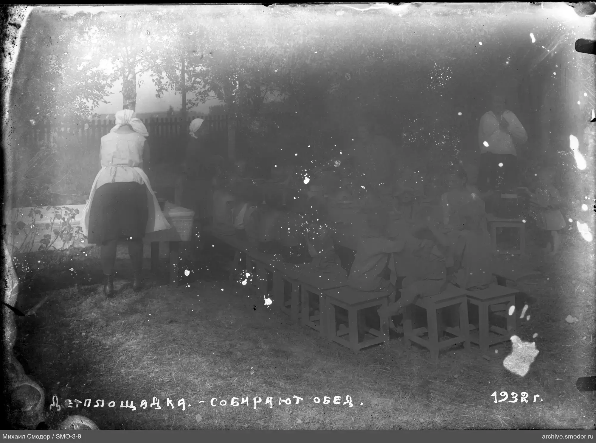 Группа детей и взрослых за столом на улице