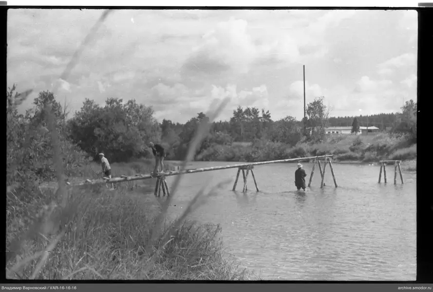Menschen an einer Holzbrücke über einem Fluss