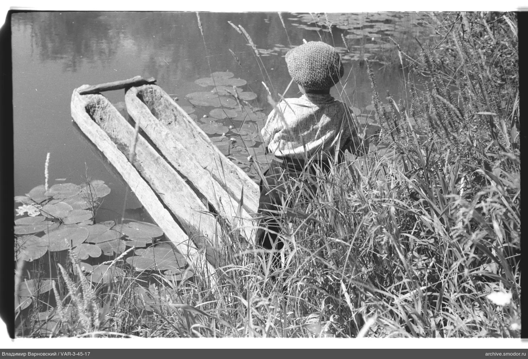 Kind am Wasser mit Booten und Seerosen