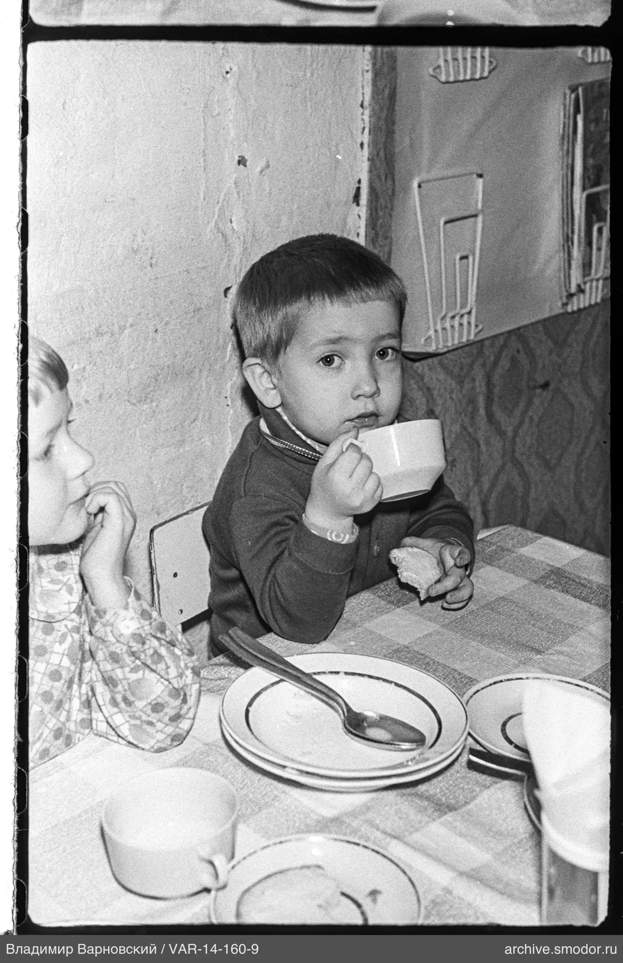Zwei Kinder am Tisch mit Geschirr