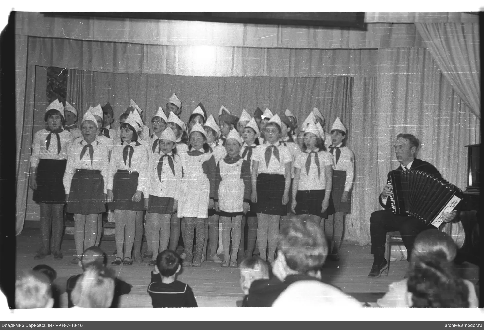 Kinder singen auf der Bühne mit Bayan-Spieler