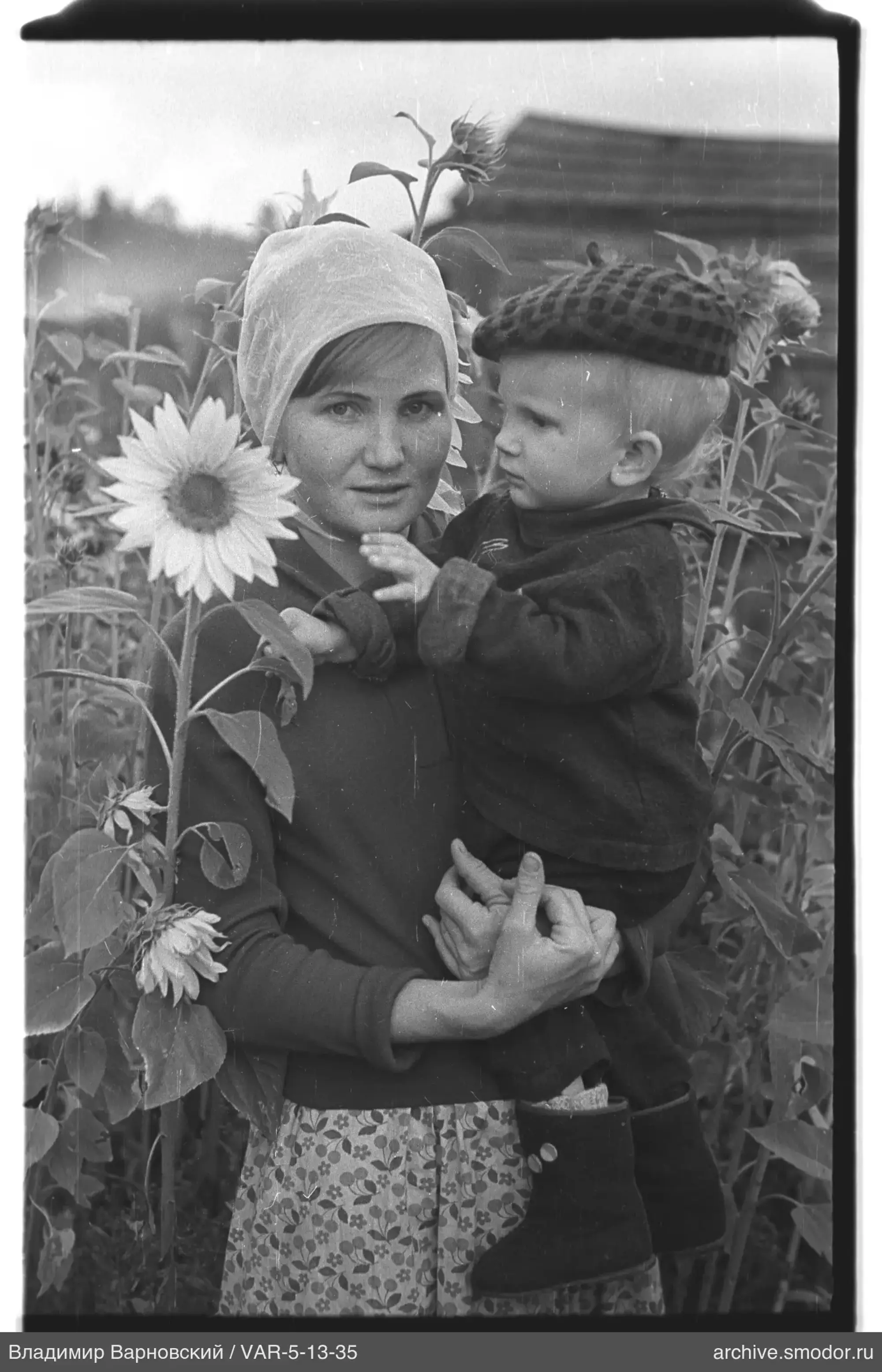 Frau mit Kind vor Sonnenblumenfeld
