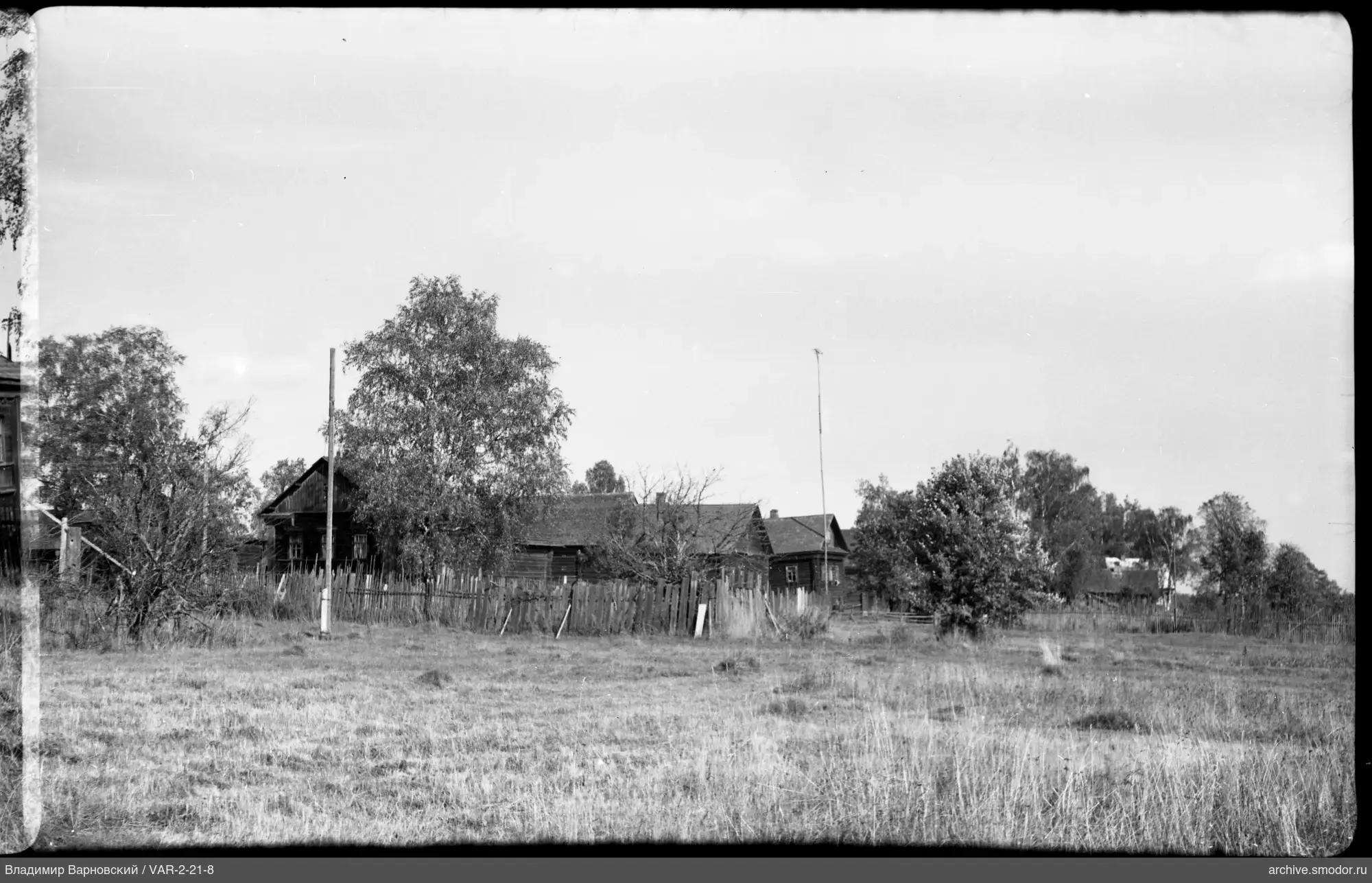 Landscape with wooden houses and field