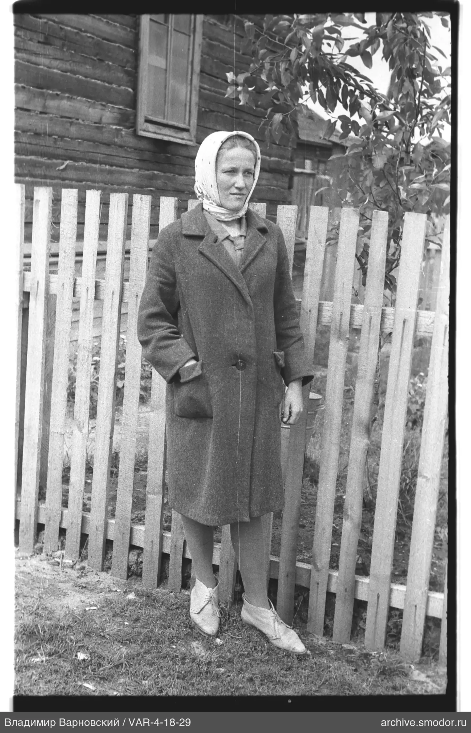 Женщина у деревянного забора