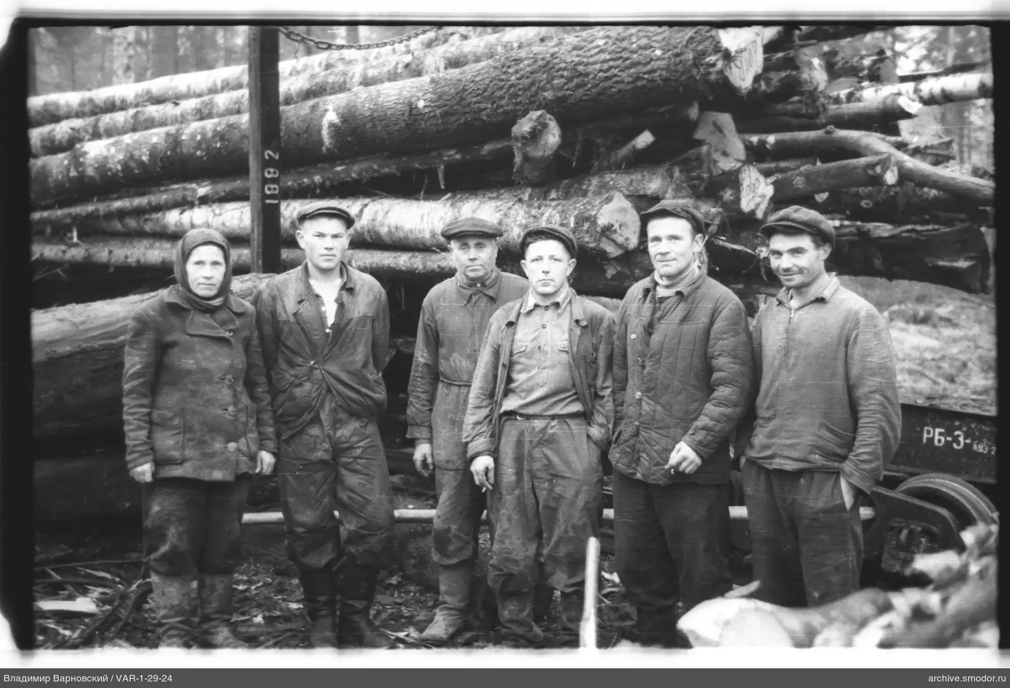 Gruppe von Menschen bei Holzstämmen auf Bahnsteig
