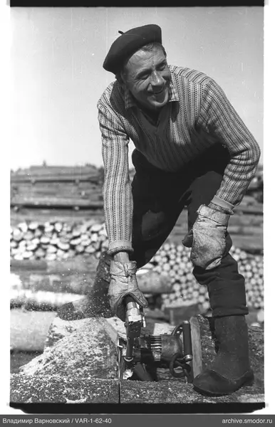 Man with an electric drawing board by logs