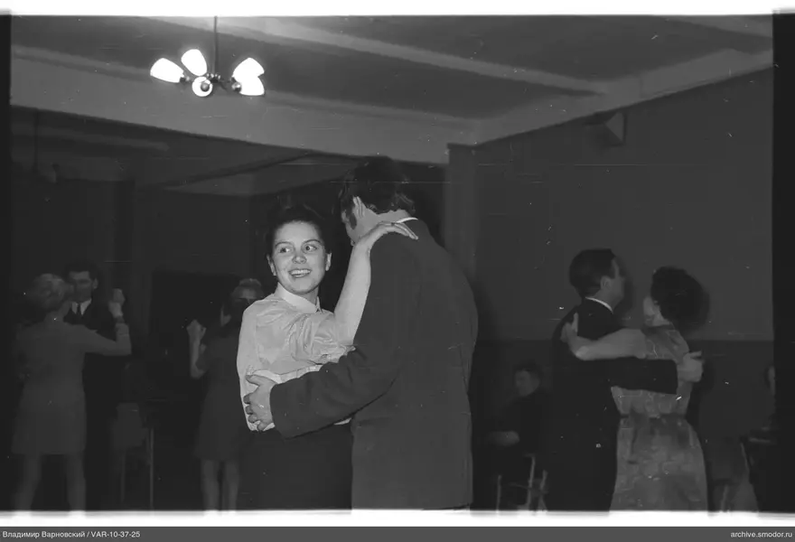 Couples dancing in a room with chandelier