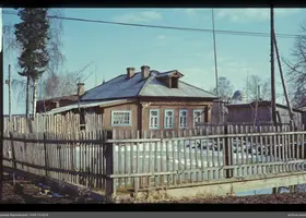 Holzhäuser mit Zaun und Bäumen