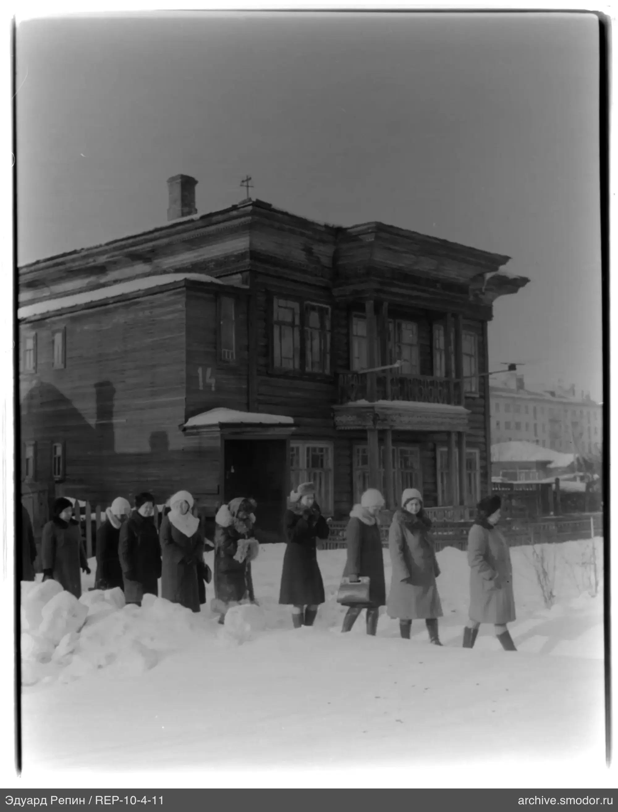 Frauen auf verschneiter Straße bei Haus