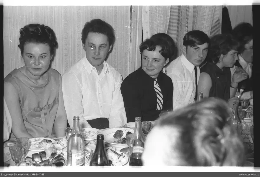 Group sitting at a table with dishes and bottles