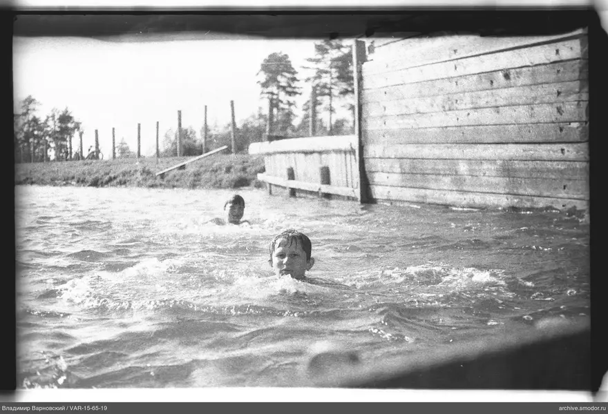 Zwei Jungen im Wasser bei einer Holzkonstruktion