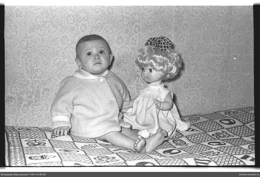 Детский портрет с куклой на фоне обоев