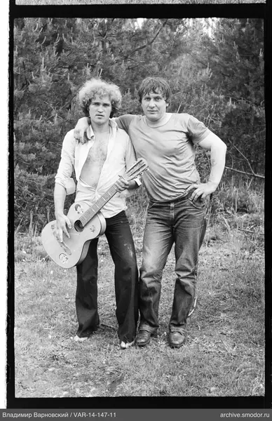 Two men on grass with guitar
