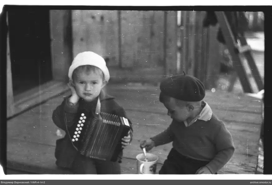 Two children with musical instrument and dishware