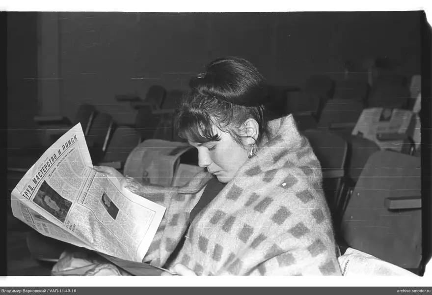 Frau im Sessel mit Zeitung