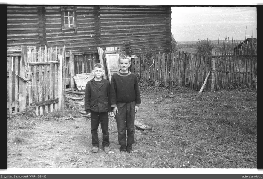 Zwei Jungen vor einem Holzhaus