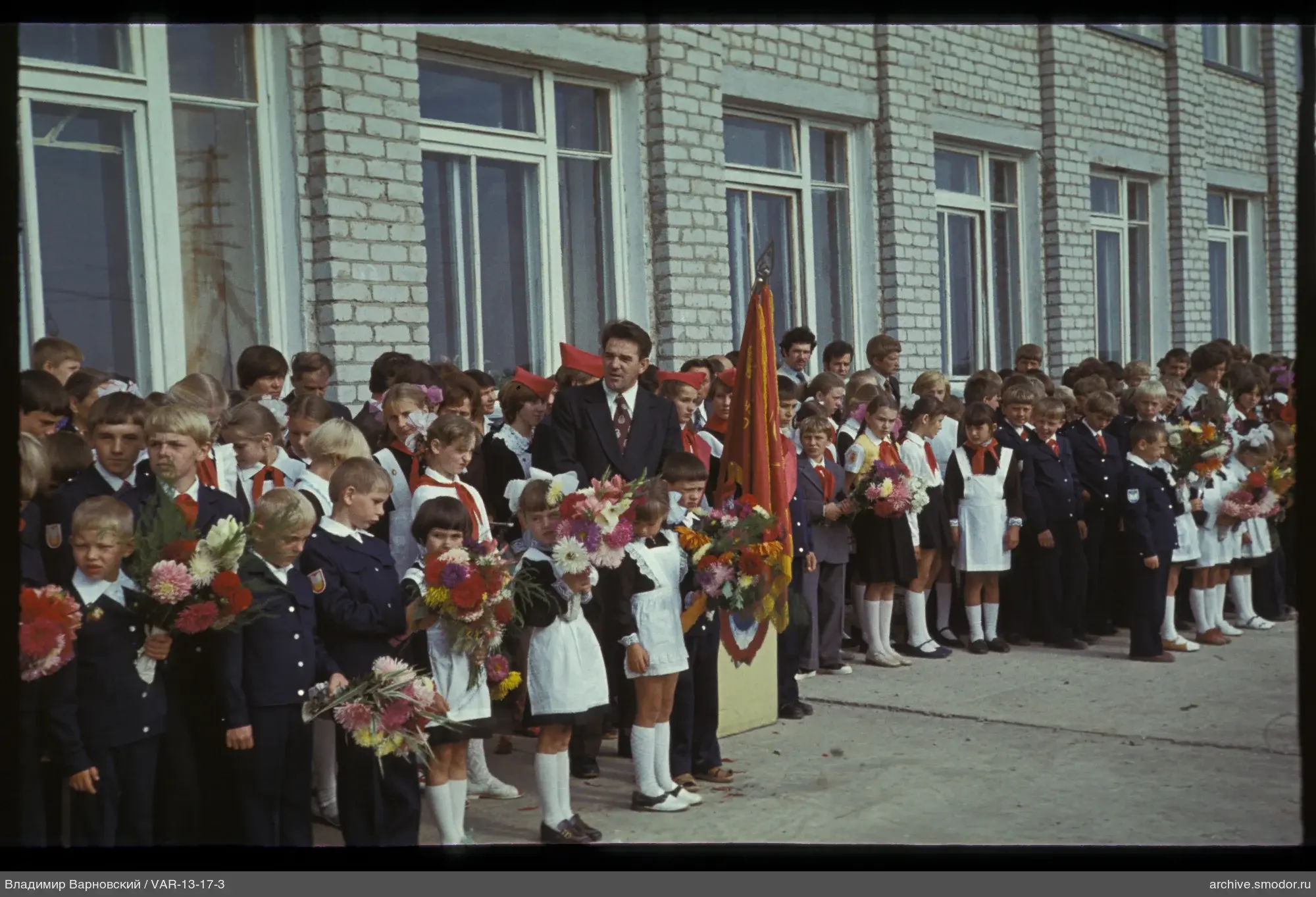 Gruppe von Kindern und Erwachsenen bei Backsteingebäude