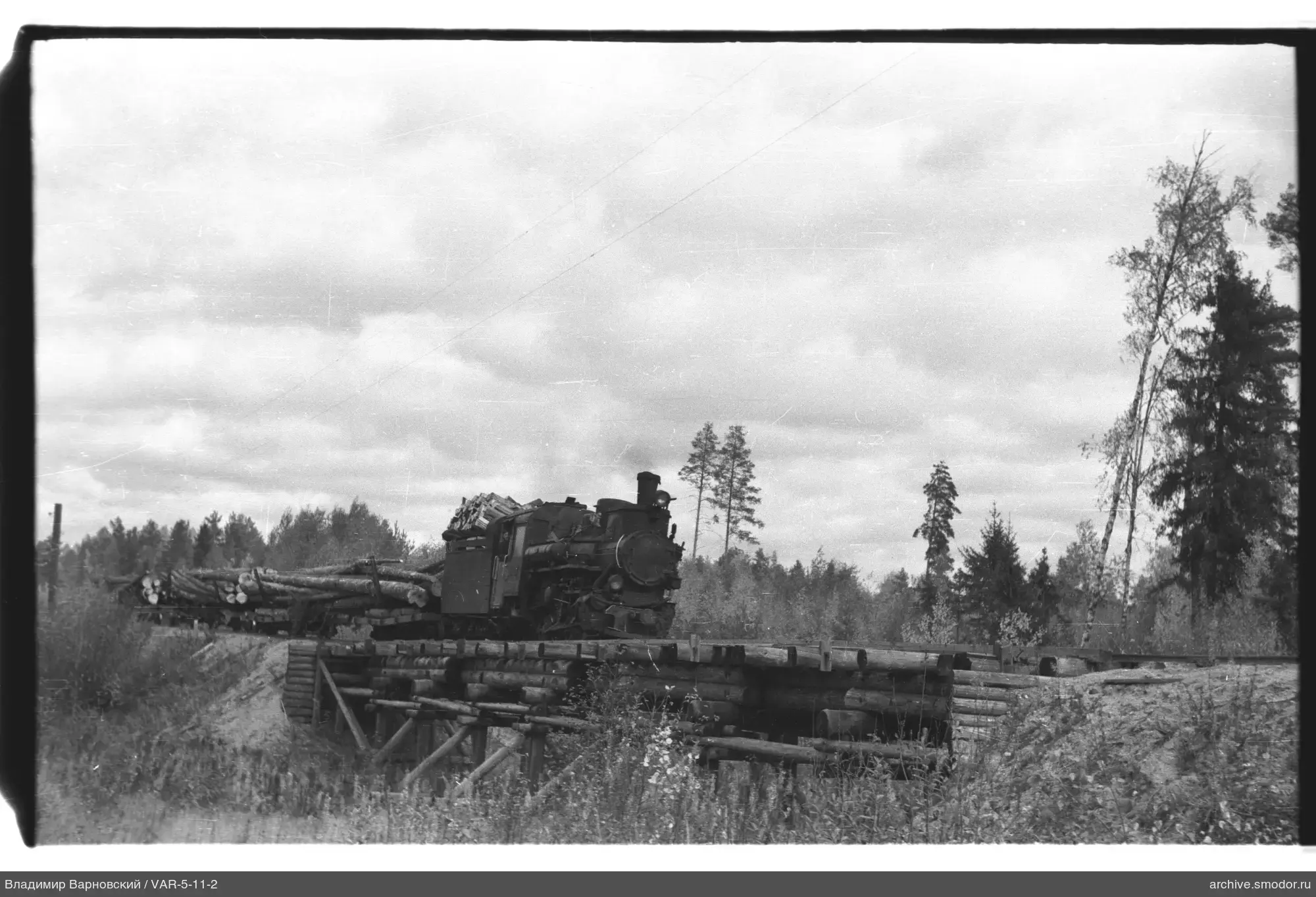 Steam locomotive with freight cars on a wooden bridge