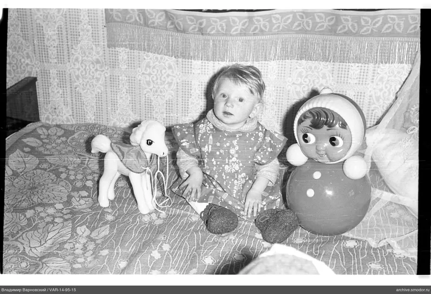 Kind mit Spielzeugen auf dem Bett