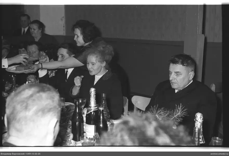 People at a table with bread and fir branch