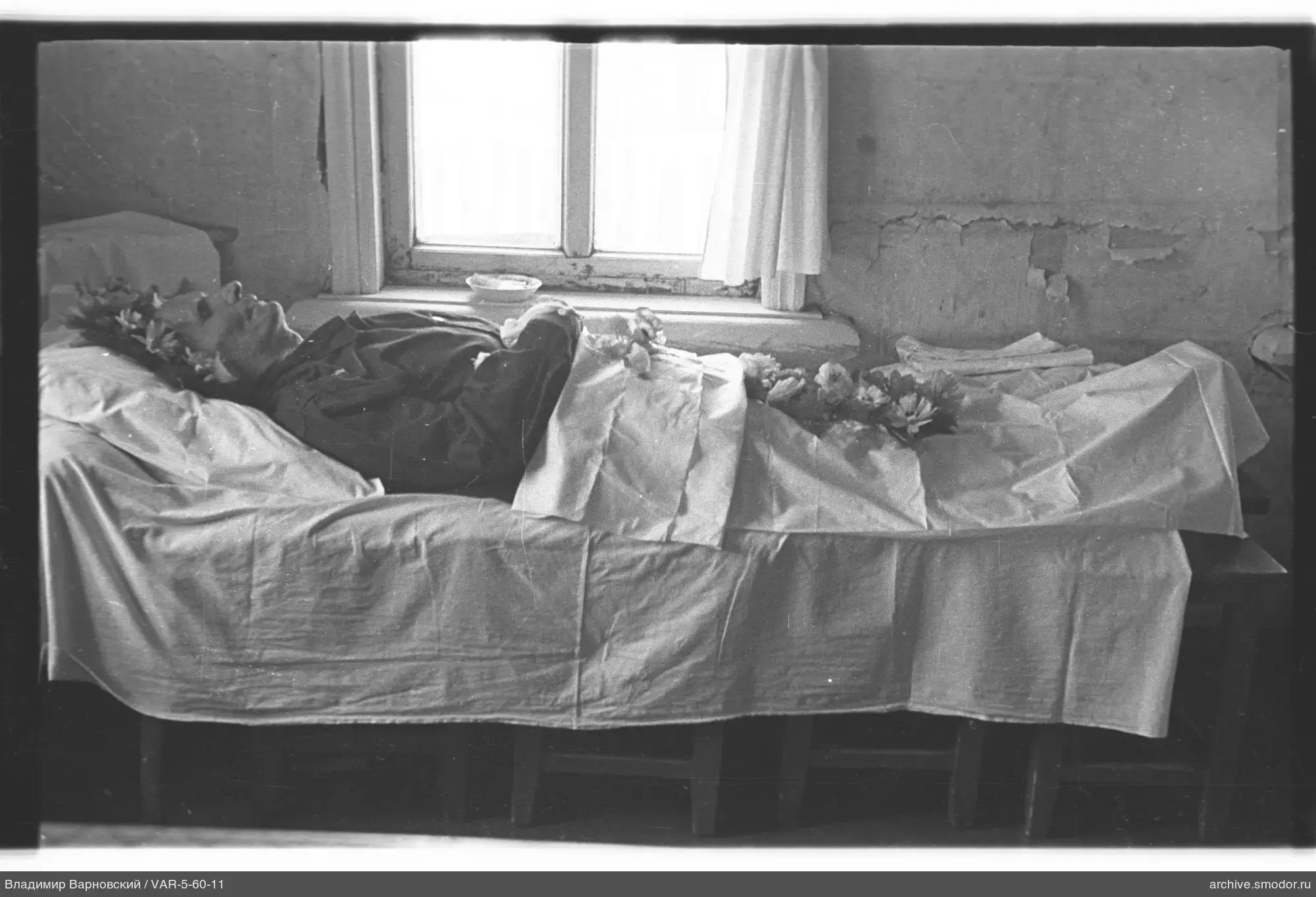 Mann mit Kranz auf dem Bett