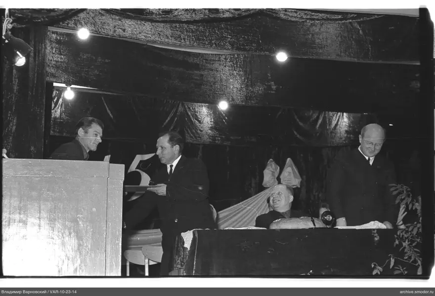Men on stage with document and bread